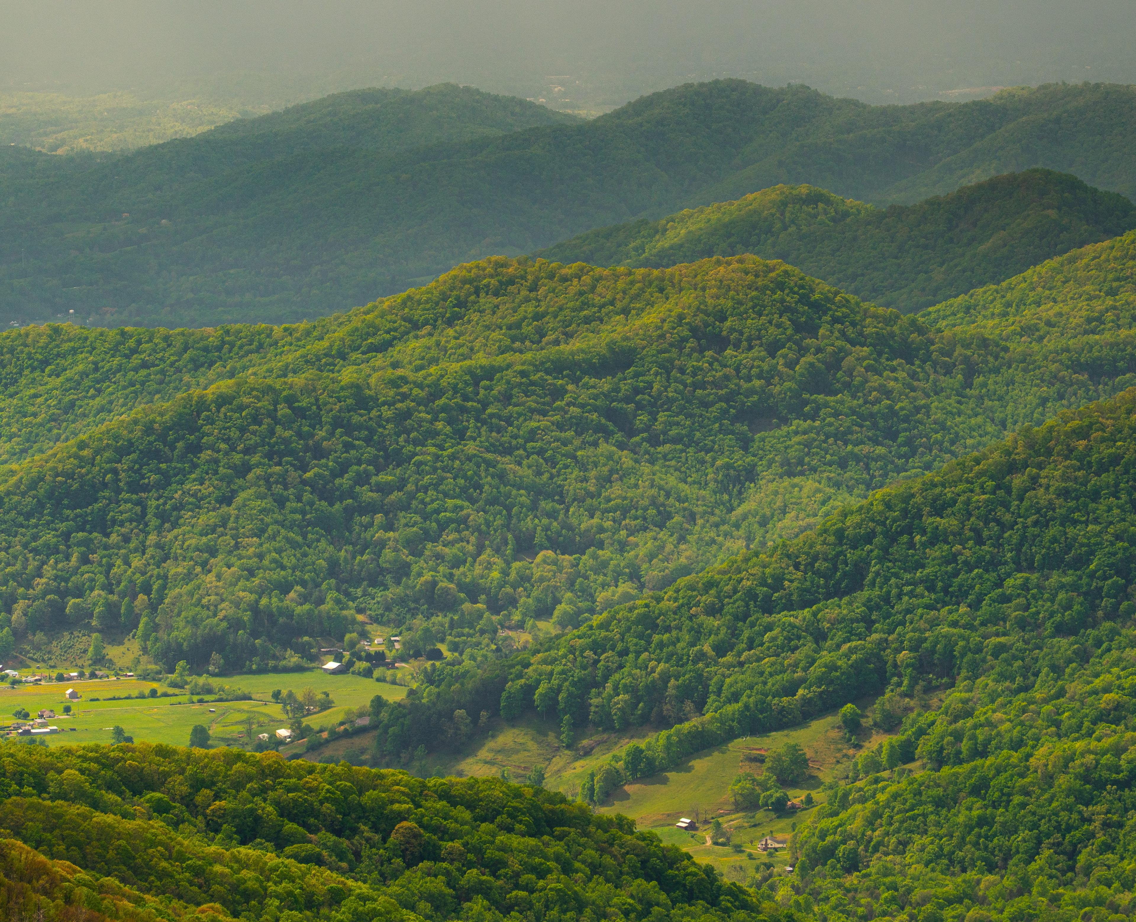 Layered green mountain ridges under hazy light